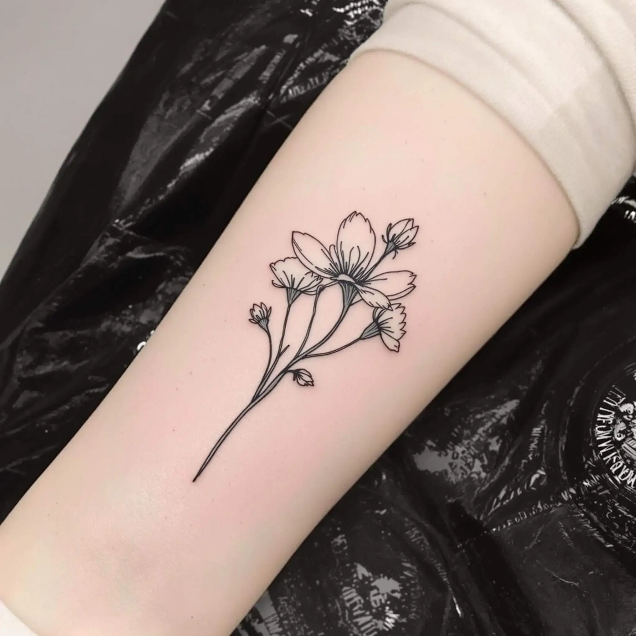 Black and gray flower tattoo with negative space