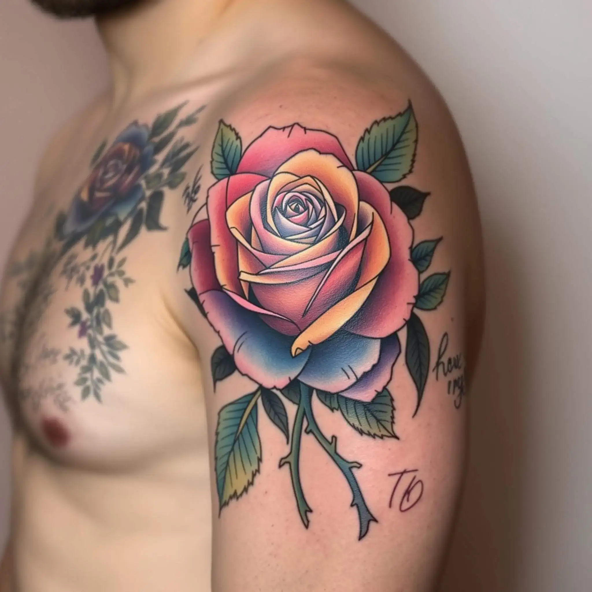 Un tatouage de rose colorée sur le haut du bras d'un homme