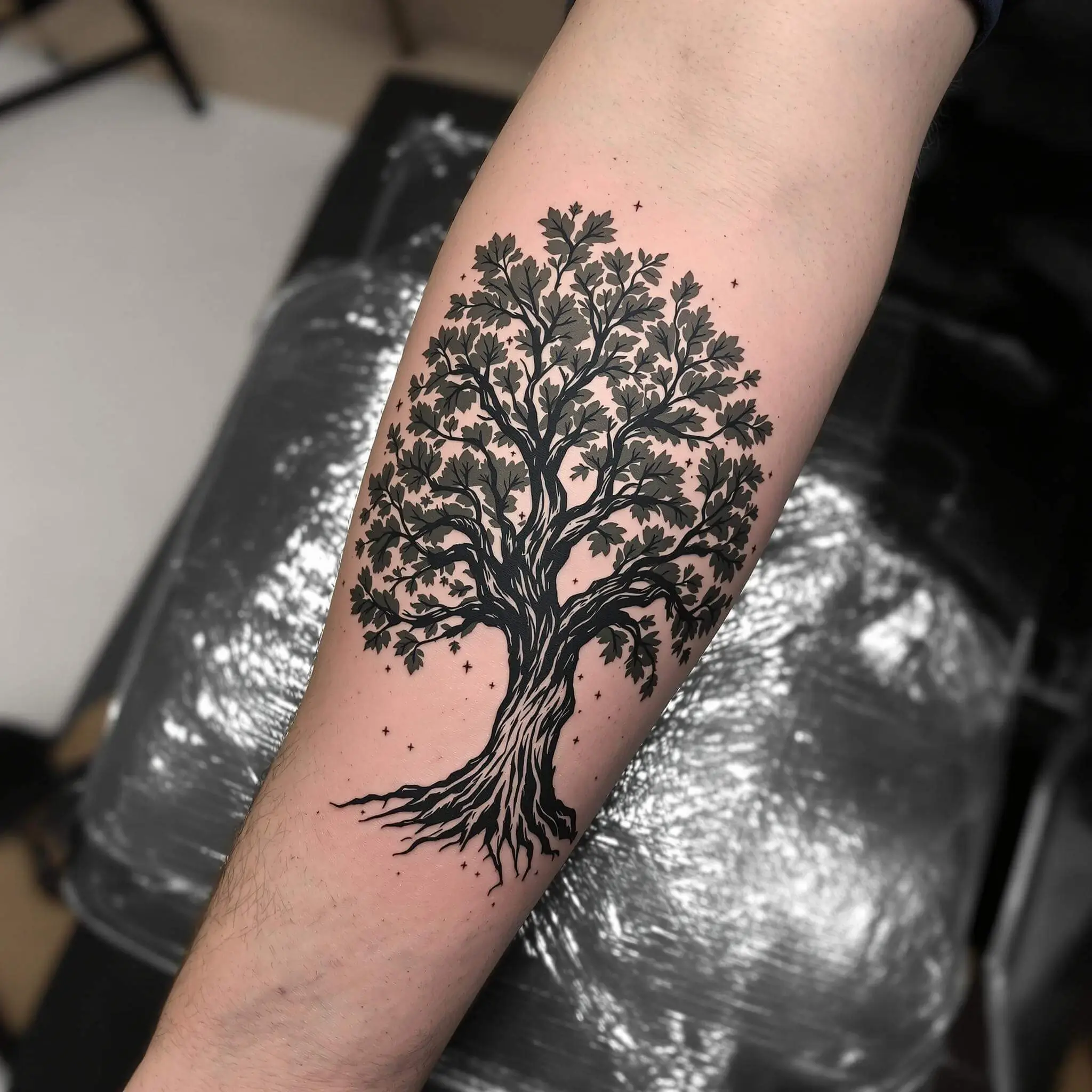 Un tatouage de chêne détaillé sur l'avant-bras d'un homme