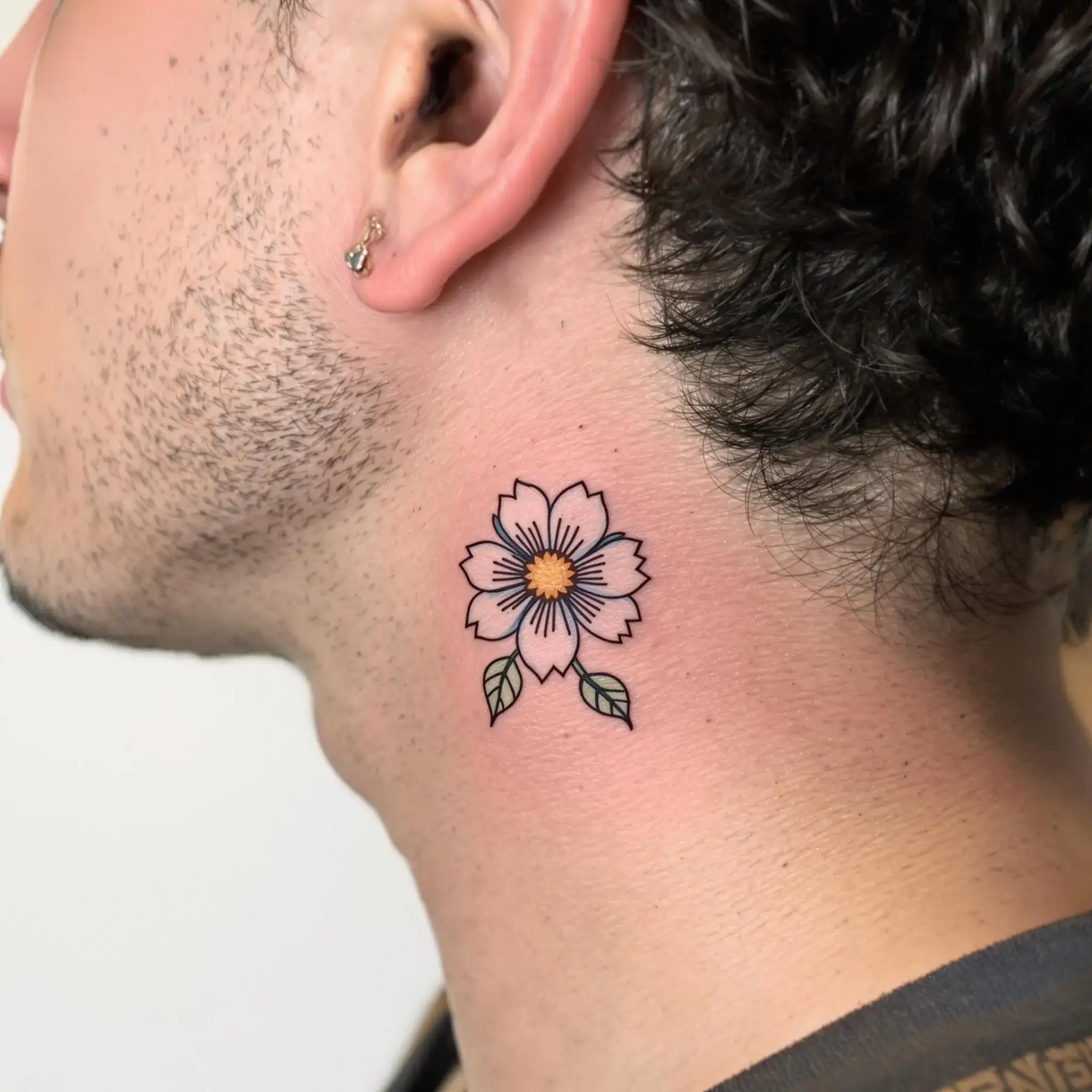 Un petit tatouage de fleur derrière l'oreille d'un homme